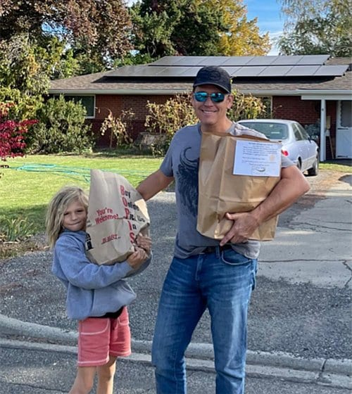 Volunteers holding bags of groceries